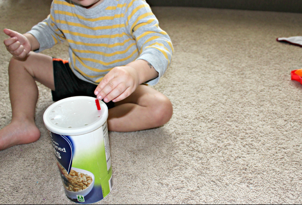 Fine Motor Skills Ideas for Toddlers and Preschoolers - Child threading pipe cleaners through a can