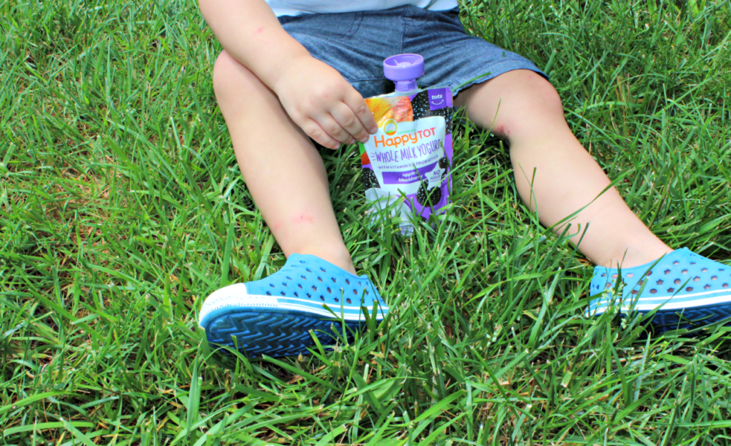 Toddler with Happy Tot Whole Milk Yogurt Pouch for a healthy snack