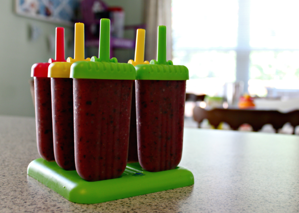 Homemade Strawberry-Blueberry Popsicles from Live Well Play Together. These homemade mixed berry pops are the perfect treat to cool off during the summer. Quick, healthy, and kid-friendly! #popsicles #frozenpops #icepops #healthysnacks #summersnacks #summerfood #strawberries #blueberries #kidfriendlyrecipes