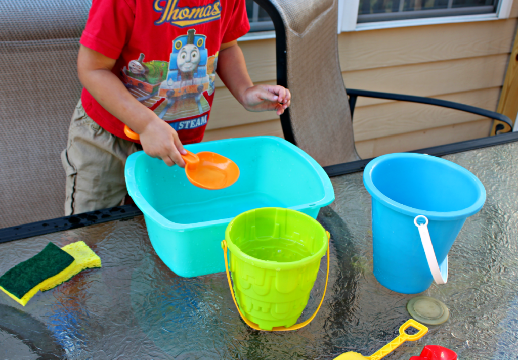 This fun water transfer activity is easy to set up and fun to play. Great water play and sensory play activity for kids. Plus extra questions for additional learning opportunities. This is an excellent way to encourage the development of motor skills and spatial awareness as children see how much water can fit into each container. #playbasedlearning #homeschool #preschool #toddleractivites #stemlearning #stemforkids #waterplay #sensorybins #scienceforkids