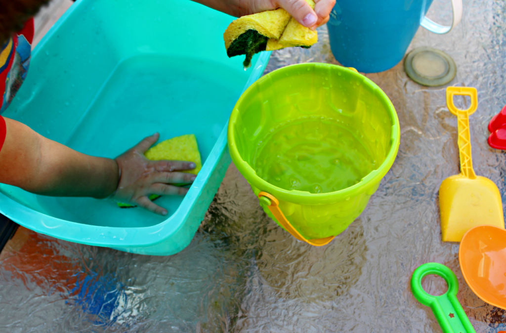 This fun water transfer activity is easy to set up and fun to play. Great water play and sensory play activity for kids. Plus extra questions for additional learning opportunities. This is an excellent way to encourage the development of motor skills and spatial awareness as children see how much water can fit into each container. #playbasedlearning #homeschool #preschool #toddleractivites #stemlearning #stemforkids #waterplay #sensorybins #scienceforkids