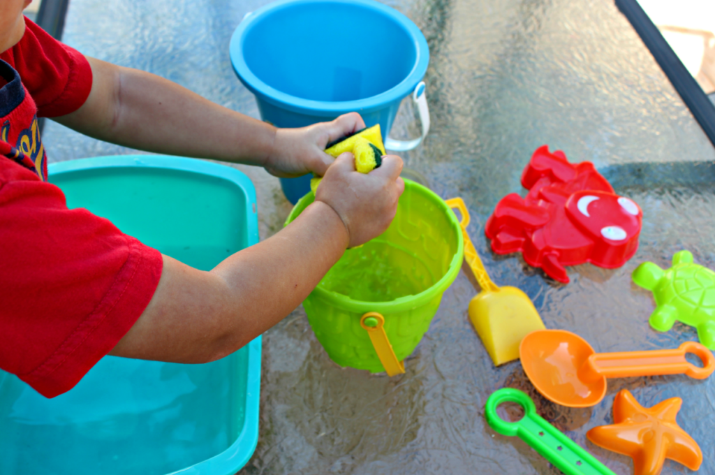 This fun water transfer activity is easy to set up and fun to play. Great water play and sensory play activity for kids. Plus extra questions for additional learning opportunities. This is an excellent way to encourage the development of motor skills and spatial awareness as children see how much water can fit into each container. #playbasedlearning #homeschool #preschool #toddleractivites #stemlearning #stemforkids #waterplay #sensorybins #scienceforkids