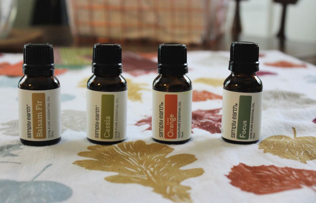Essential Oil Bottles on a Table - Balsam Fir, Cassia, Orange, and Focus Blend Oils from Simply Earth Essential Oils