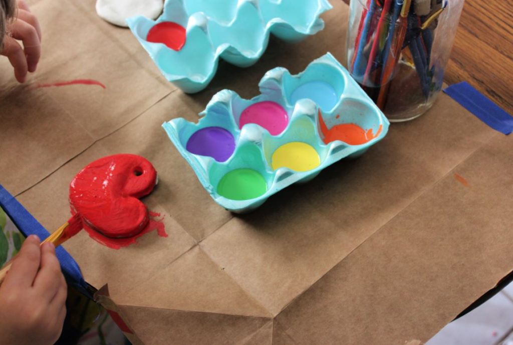 Painting Heart shaped salt dough ornaments with acrylic paint for Valentine's Day!  The perfect Valentine's Day activity for toddlers and preschoolers!