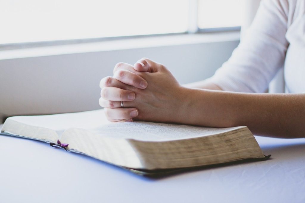 woman's hands on bible. Praying for your spouse and your marriage