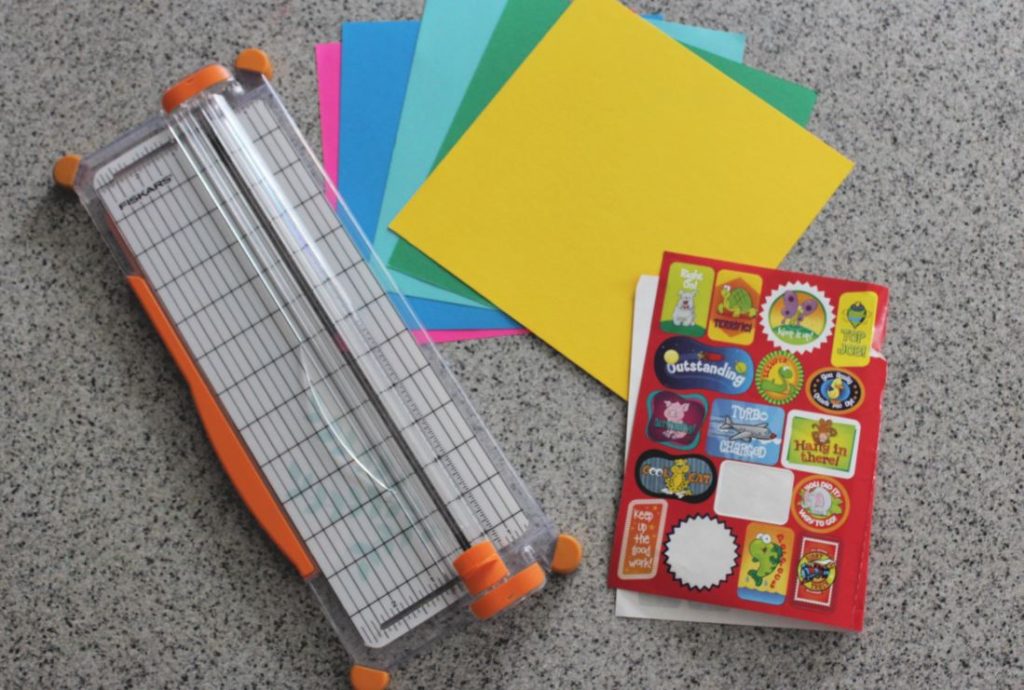 Paper cutter, card stock, and stickers - supplies to make your own DIY Bookmarks