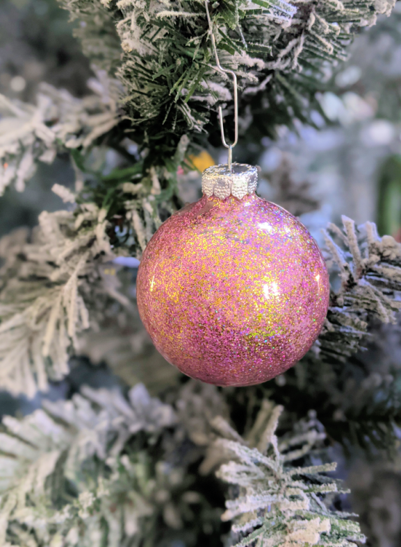 Purple and gold glitter bauble ornament on the Christmas tree. Learn how to make your own DIY glitter ornaments with this easy to follow tutorial.