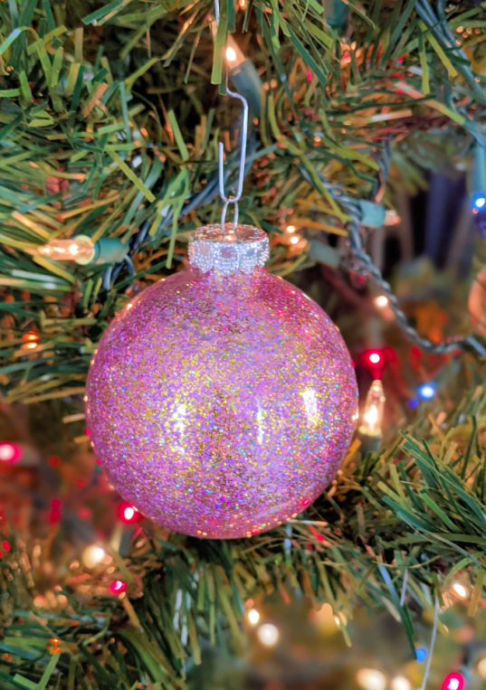 DIY Glitter ornament hanging on a Christmas tree. Get the full step by step tutorial to make your own ornaments at home!