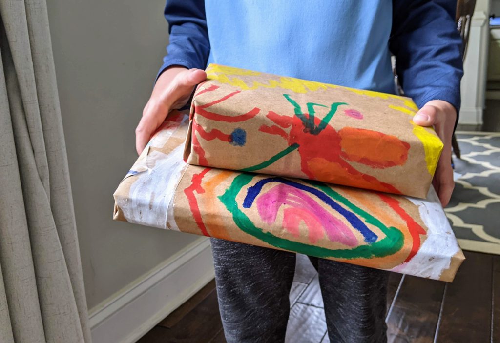 Child holding gifts with DIY Wrapping Paper